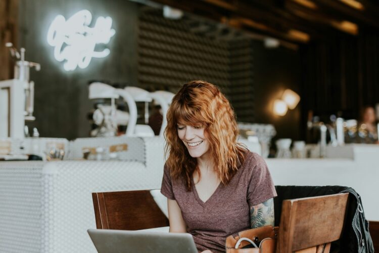 Woman sitting at cafe working on computer